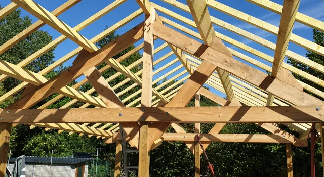 Vue élargie d'une charpente en bois conçue par Alternative Bois Concept sur un chantier de construction