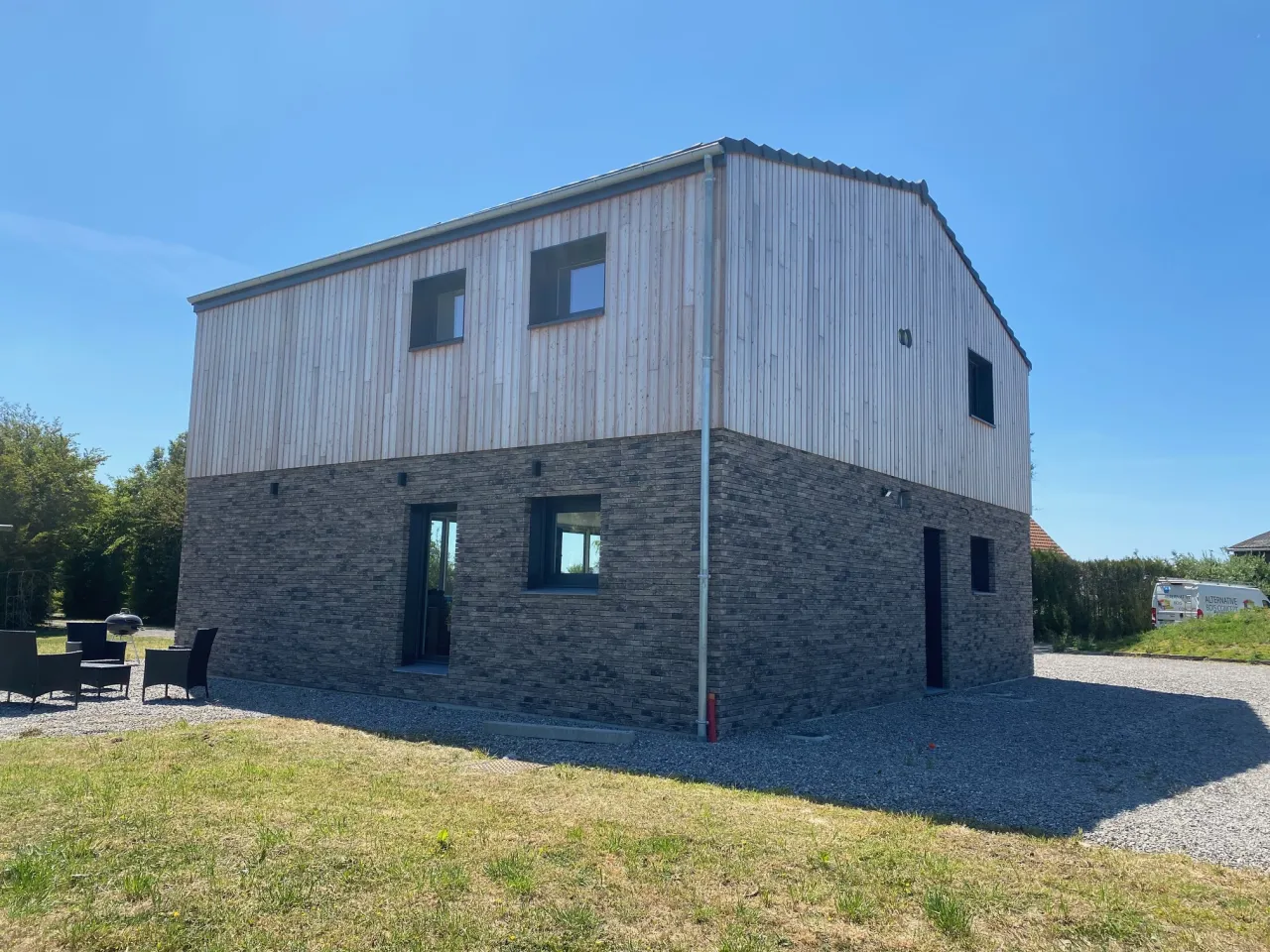 Vue extérieure de la maison individuelle de Rexpoëde, sur sa façade arrière, réalisée par Alternative Bois Concept