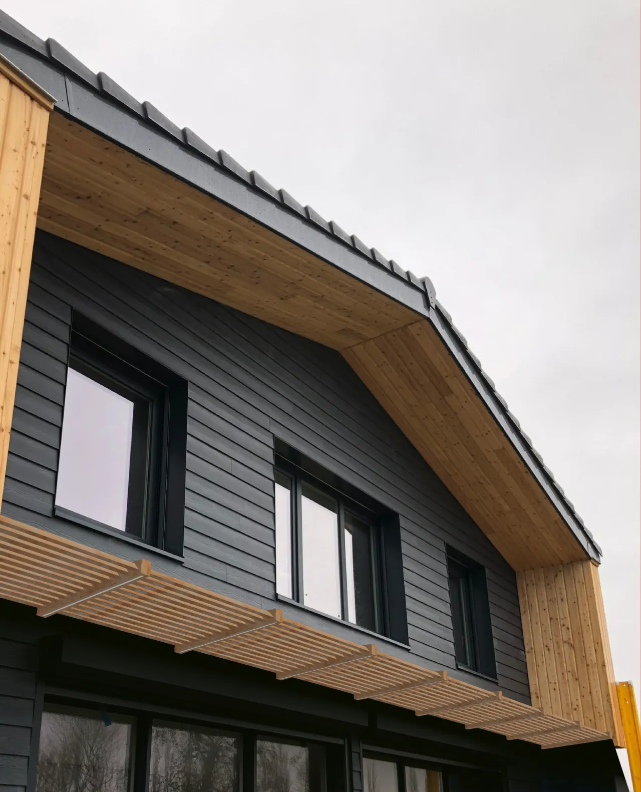 Vue centrée sur l'auvent de la maison individuelle à ossature bois construite par Alternative Bois Concept à Rexpoëde.