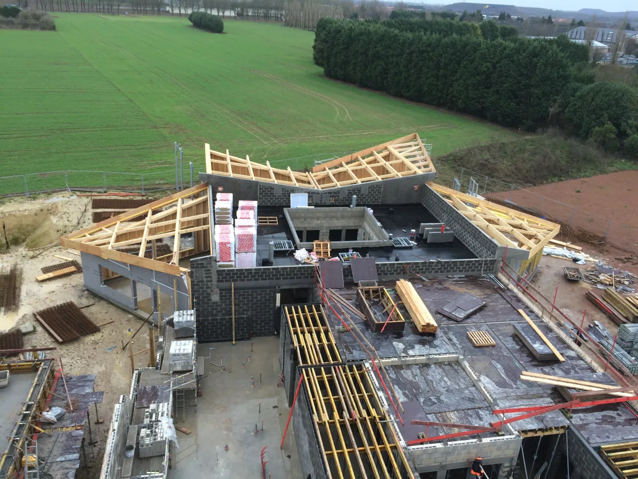 Vue aérienne du chantier de couverture de la cantine de Loison-sous-Lens, présente à la fois les éléments de construction et les matériaux employés par Alternative Bois Concept.